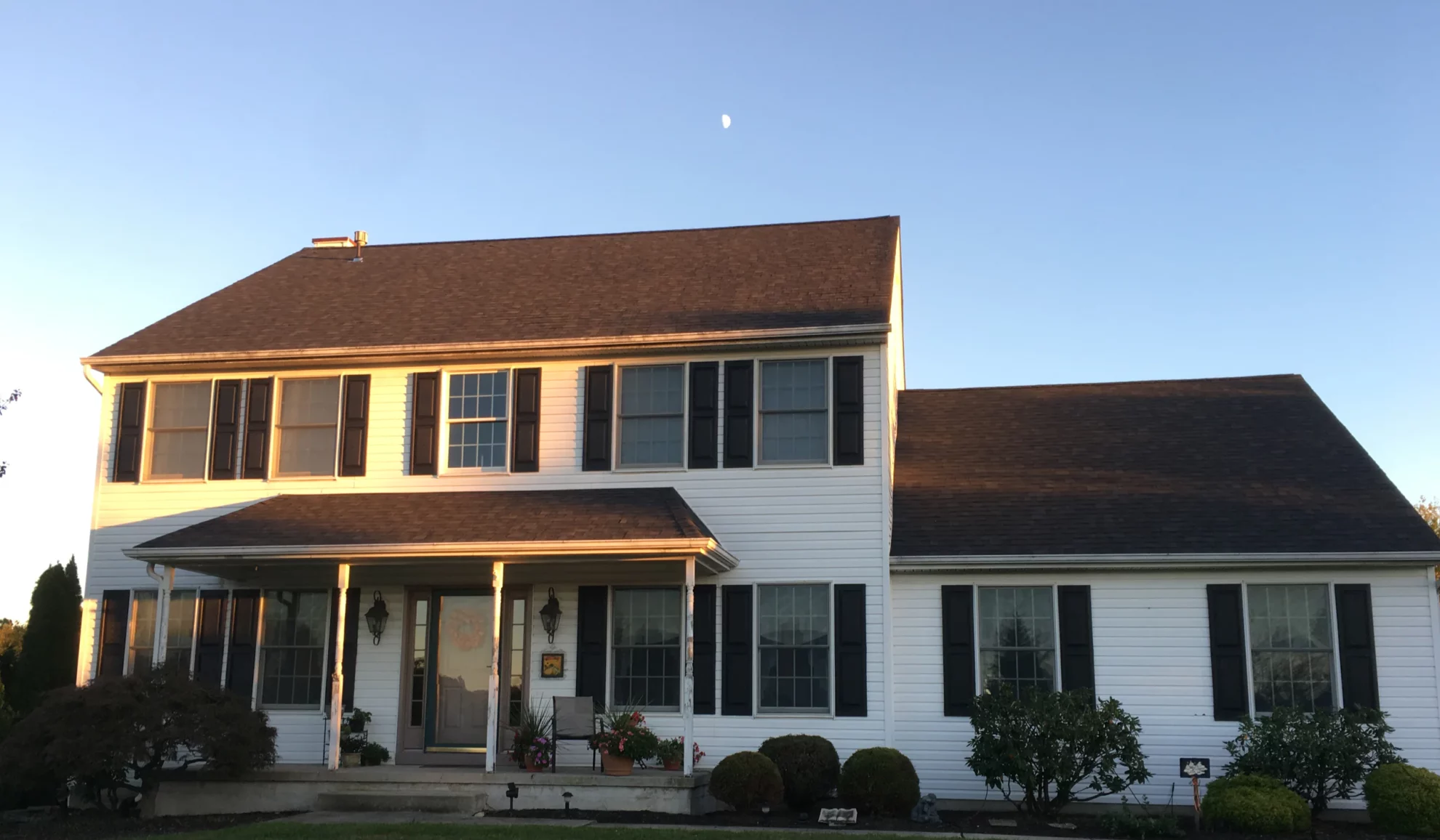 two storey house newly installed asphalt shingles at golden hour atco nj